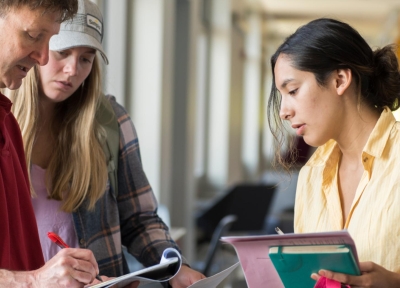 Two students work with stats faculty Jeff Kollath